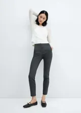 Pantalón de vestir gris oscuro, de corte skinny, tiro medio, con bolsillos laterales y traseros.