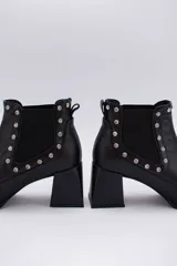Botas cortas negras de cuero con elásticos laterales, taco cuadrado y apliques de tachas plateadas.