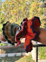 Gomita de pelo tejida al crochet con hilo de algodón a rayas en tonos rosa y violeta, con borde gris.