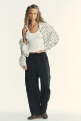 Top blanco de morley con escote redondo y tirantes. Detalle de flor en relieve combinada al tono.