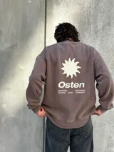 Buzo marrón con estampado en la espalda que incluye un sol, la palabra "Osten" y las frases "Empower Elevate Your" y "Boldness Strenght".
