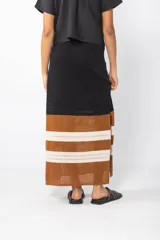 Falda larga tejida a crochet con cintura elastizada y cordón ajustable. Diseño con rayas horizontales en color marrón, blanco y negro.