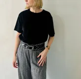 Blusa negra de terciopelo plisado con mangas cortas y cuello redondo.