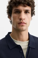 Polo de punto azul marino de corte regular fit, tejido en hilatura con mezcla de algodón y seda. Tiene cuello solapa con cierre frontal de botonadura, manga larga y acabados en rib.
