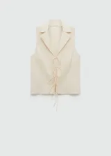 Blusa negra sin mangas con cuello camisero y cierre de lazos en la parte delantera.