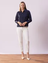 Camisa blanca de gasa, marca Sioni, con cuello con solapa, abertura central con botones y mangas largas con puño y botón.