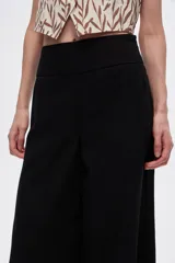 Pantalón negro de lino, de corte ancho y tiro alto.