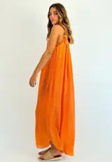 Vestido largo color naranja, de corte recto y escote halter con detalle de volados.