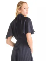 Vestido midi plisado color beige, marca Julia Jordan. Cuello alto con punto smock, mangas amplias tipo mariposa y cintura elastizada con punto smock. Espalda con botones y abertura central. Forro interno a tono.