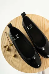 Zapato tipo ballerina color beige con correa al tobillo desmontable.