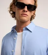 Camisa de vestir celeste en modelo slim fit, con cuello inglés, abotonada adelante, de manga larga con botones en los puños. Confeccionada con tecnología easy care performance que permite mayor elasticidad, secado rápido y menos arrugas.