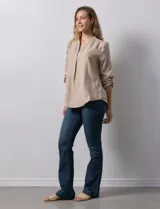 Blusa color beige de poliéster con escote en V y mangas 3/4 regulables con presilla y botón.