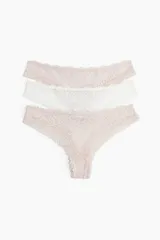 Pack de tres bombachas tipo brazilian de encaje, una color rosa pálido, una color blanco y otra color beige.