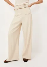 Pantalón de vestir color beige, de corte recto y tiro alto, con bolsillos laterales y traseros.