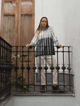 Sweater tejido a rayas horizontales color beige, marrón y negro, de cuello alto y corte holgado.