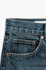 Pantalón de jean azul de corte wide leg, tiro alto y largo hasta el tobillo.