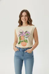 Musculosa blanca de algodón con estampado de una pimienta y la palabra "Pimienta" en letras rosas, amarillas y verdes. Tiene cuello redondo y sisas amplias.