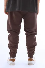 Pantalón de jogging marrón de algodón grueso con interior abrigado, corte amplio, tiro medio, cintura elástica con cordón, bordado mini “vernal” en pierna izquierda, cierres en botamanga para regular el ajuste y detalle de logo V en bordado mini sobre la pantorrilla.