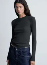 Camiseta negra de punto de canalé, cuello redondo y manga larga.