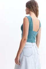 Musculosa cropped color ladrillo, de corte ajustado y espalda descubierta.