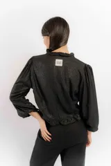 Blusa color blanco de lino, con mangas 3/4 y volados en el frente. Se ata con lazos en el centro.