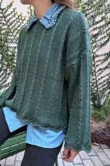 Sweater verde oscuro de tejido de punto con textura y brillo, de grosor intermedio y largo a la cadera.