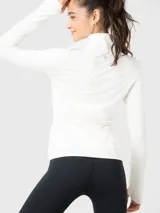 Buzo deportivo blanco de tela suave y delgada con medio cierre frontal, mangas largas con orificios para los pulgares y logo en el pecho.