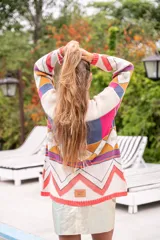 Sweater de punto con diseño geométrico en tonos naranja, morado y crema, de corte holgado.