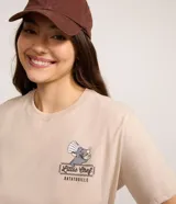 Remera de manga corta y escote redondo, color beige, con un pequeño estampado localizado en el pecho del personaje Remy de Ratatouille con el texto "Little Chef Ratatouille".