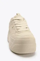 Zapatillas deportivas color beige con plataforma alta. Cierre con cordones.