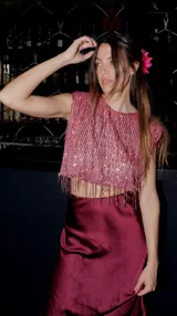 Top rosa con flecos de lentejuelas, hombreras y elástico.