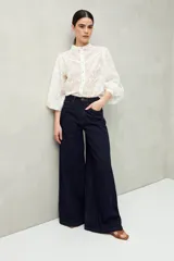 Jean azul oscuro de calce ultra wide leg, tiro alto y silueta amplia. Diseño clásico de cinco bolsillos y cierre con botón metálico y cremallera.