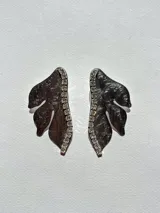 Par de aros con forma de hoja color negro con borde de strass plateado.