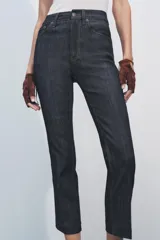 Pantalón de jean de tiro alto color negro con pierna ancha, bolsillos delanteros y traseros, y cierre frontal con cremallera y botón metálico.