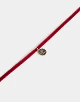 Gargantilla choker de terciopelo color borgoña con dije de moneda dorada con diseño de rosa en relieve.
