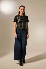 Chaleco negro de eco-cuero con textura de cocodrilo, corte entallado y cierre frontal con botones metálicos.