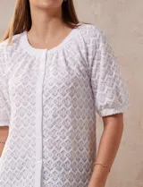 Blusa blanca labrada con cuello a la base, abertura central con botones y mangas cortas. Marca Sabrina Lauren.