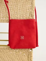 Bandolera azul de cuero gamuzado, con correa larga de soga azul y logo bordado en rojo.