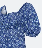 Vestido corto azul con estampado floral blanco, escote cuadrado, mangas cortas abullonadas y textura.