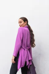 Camisa manga larga color beige con textura plumetie, abotonada en el pecho y lazo regulable que permite múltiples usos.