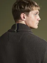 Sweater verde seco de tejido de punto con cuello alto y cierre frontal con cremallera.