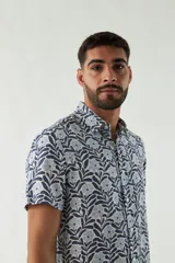 Camisa de hombre estampada, de manga corta y fit slim. Presenta cartera abotonada y logo bordado.