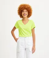 Blusa blanca de algodón con cuello en V, manga corta y bolsillo frontal.