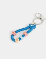 Llavero con dije de celular azul con detalles en amarillo y blanco. Incluye un strap con forma de gusano azul con detalles de estrellas y círculos de colores.