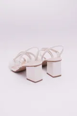 Sandalias de ecocuero charolado color negro, con punta cuadrada, dos tiras horizontales sobre el empeine, pulsera con hebilla al tobillo y taco cuadrado.