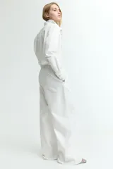 Pantalón de corte holgado color blanco, confeccionado en denim extrasuave. Modelo con cintura elástica, cordón para ajustar, bolsillos laterales discretos y piernas anchas.