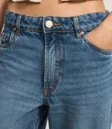 Pantalón de jean azul, de corte ancho, con bolsillos delanteros y traseros, y ruedo con dobladillo.