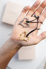 Collar con cordón negro y dije de corazón dorado con efecto dripping.