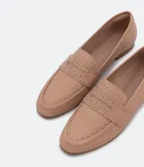 Zapato loafer flat color nude con tachas y taco bajo.