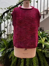 Chaleco negro tejido a mano en dos agujas con hilado 100% baby alpaca, ligeramente oversize, de hombros anchos y cuello tipo bote, con puntos calados en frente y espalda y tajos a los lados en el bajo.